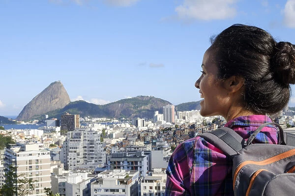 Young backpacker on her mobile phone in central Rio de Janeiro with the Sugar Loaf in the distance