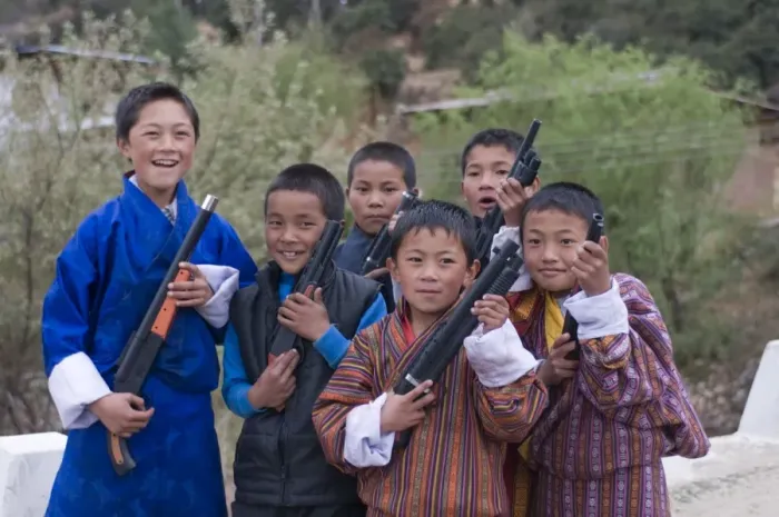 Framed Print : Young Bhutanese boys playing with their toy guns, Paro, Bhutan, Asia