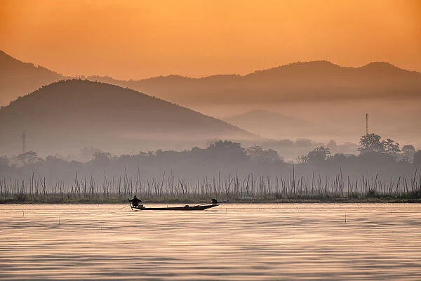 Young fisherman with net at sunrise, Inle Lake, Shan state, Myanmar (Burma), Asia