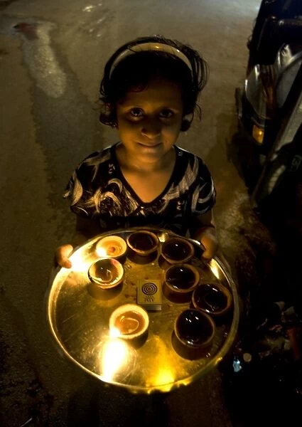Young girl carrying deepak lights on tray at Diwali, Udaipur, Rajasthan, India, Asia