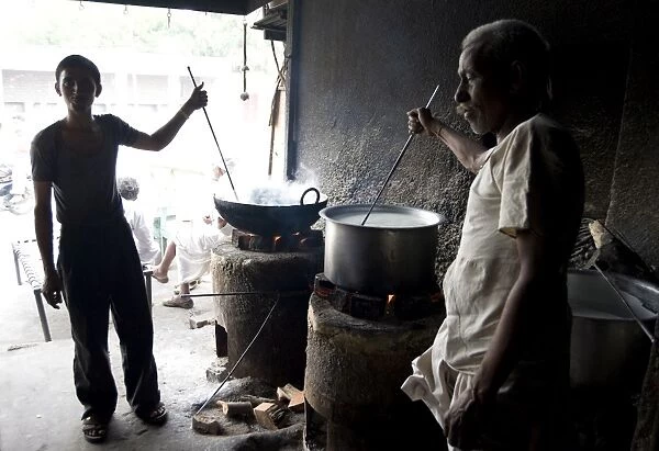 Young man and blind man stirring milk for chai, roadside chai stall, Dangiyawas