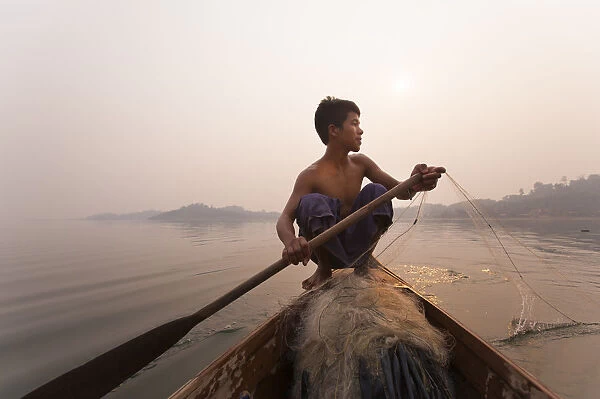 A young man pulls in his nets at the end of the day on Indawgyi Lake, Kachin State