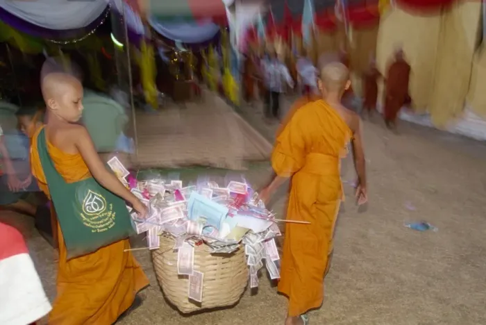 Framed Print : Two young monks carrying basket of donations during Framed Print : Two young monks carrying basket of donations during