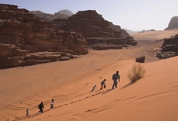 Young people climbing a typical red sand dune with