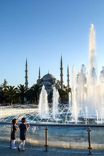 Two young Turkish girls pointing to the Blue Mosque, UNESCO World Heritage Site