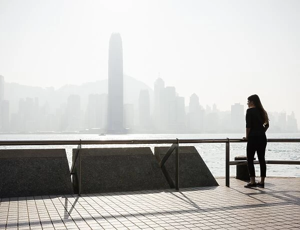 Young woman standing on Tsim Sha Tsui Waterfront, Kowloon, Hong Kong, China, Asia