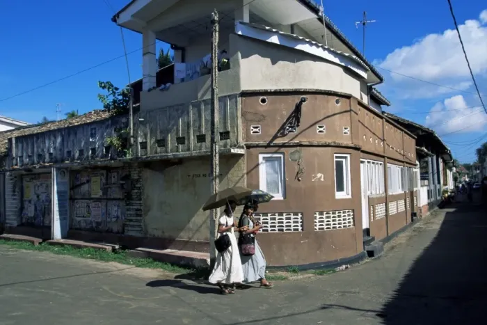 Framed Print : Young women walking round a corner on a street in Galle