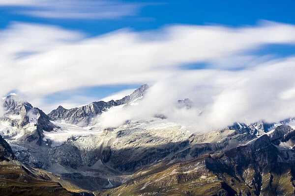 Zinalrothorn and Wellenkuppe mountains emerging from cumulus clouds, Valais Canton