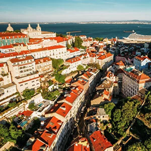 Aerial drone view of Miradouro da Graca with National Pantheon visible on far left, and large cruise ship moored on the Tagus River harbour, Lisbon, Portugal, Europe