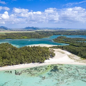 Aerial by drone of white sand beach with turquoise sea surrounded by tropical trees