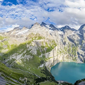 Aerial panoramic of Oeschinensee lake surrounded by woods in summer, Bernese Oberland