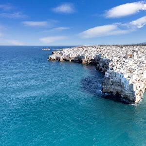 Aerial view of crystal sea surrounding Polignano a Mare on cliffs, province of Bari