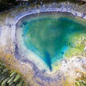 Aerial view by drone of heart shaped Carezza Lake, Dolomites, South Tyrol, Italy, Europe