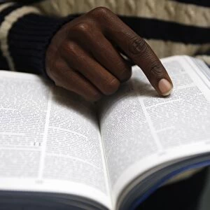 African man reading the Bible in a church, Paris, France, Europe