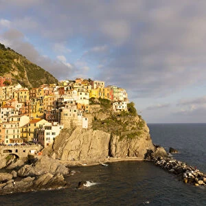 Afternoon sun and colourful buildings by sea in Manarola, Cinque Terre, UNESCO World Heritage Site
