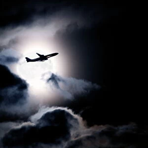 Aircraft taking off from Heathrow passing in front of full moon, London