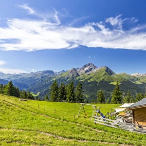 Alpine hut with Swiss flag beneath stunning clouds, Urses, Surselva, Graubunden