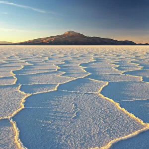 An Andean volcano rises above the Salar de Uyuni, the incredible salt desert, during