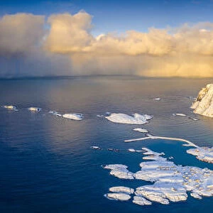 Arctic sunrise on snow capped mountains and cold sea, aerial view, Sorvaer, Soroya Island