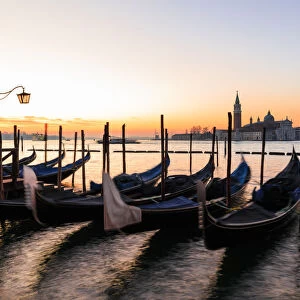 Beautiful Venetian sunrise in winter, gondolas, San Giorgio Maggiore and Lido, Venice