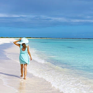 Beautiful woman walking on idyllic beach washed by Caribbean Sea, Barbuda, Antigua and Barbuda, West Indies, Caribbean, Central America