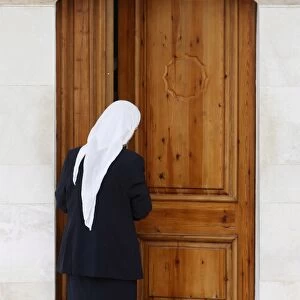 Bektachi woman opening the door of a turbe (shrine with saints tombs)