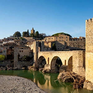 Besalu historic medieval city with Catalonia flags on the stone bridge tower crossing El Fluvia river, Besalu, Catalonia, Spain, Europe