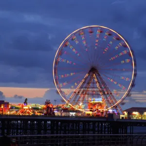 Big wheel and funfair on Central Pier lit at dusk, Blackpool Illuminations, Blackpool