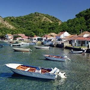 Boats moored behind houses built on the beach of a bay