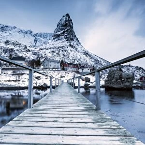 A bridge over the cold sea connects a typical fishing village. Reine, Lofoten Islands