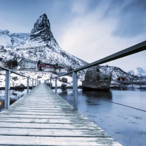 A bridge over the cold sea connects a typical fishing village. Reine, Lofoten Islands