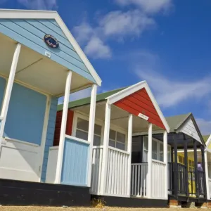 Brightly painted beach huts in the afternoon sunshine, on the seafront promenade