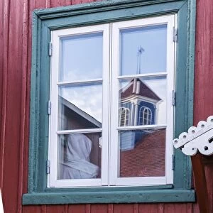 Brightly painted house reflected in window in Sisimiut, Greenland, Polar Regions curve adjustments, boosted bluish shadows and rediish highlights