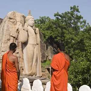 Buddhist monks in front of the giant standing statue