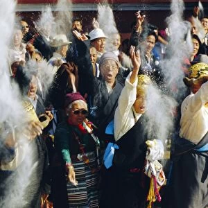 Buddhist people throwing flour into the air