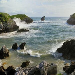 Buelna beach and karst limestone El Picon rock pillar at high tide on a windy day, near Llanes, Asturias, Spain, Europe