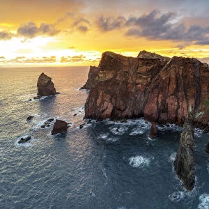 Burning sky at dawn on cliffs washed by ocean, Ponta do Rosto viewpoint