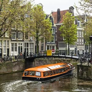 Canal boat passing under a bridge on Brouwersgracht, Amsterdam, Netherlands, Europe