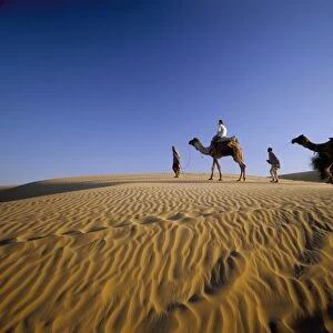 Caravan of people and camels in the Thar Desert
