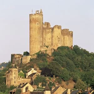 The castle towering above village houses, in early morning light, Najac