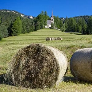 Church and hay bales, Vigo di Fassa, Fassa Valley, Trento Province, Trentino-Alto Adige / South Tyrol, Italian Dolomites, Italy, Europe