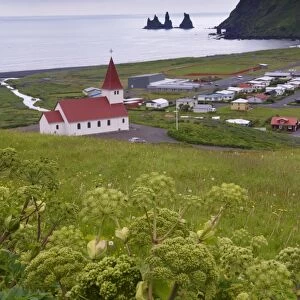 Church and village of Vik (Vik a Myrdal) and Reynisdrangar sea stacks in the distance