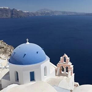 Classic view over the Caldera showing blue domed church and pink belltower, Oia, Santorini