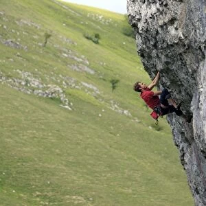 A climber scales a limestone cliff in Upper Wharfedale, Yorkshire Dales National Park