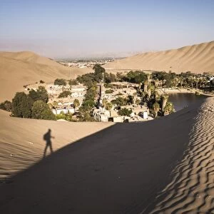 Climbing sand dunes at sunset at Huacachina, a village in the desert, Ica Region