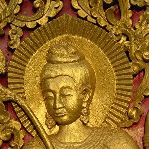 Close up of a figure carved in relif and gilded on