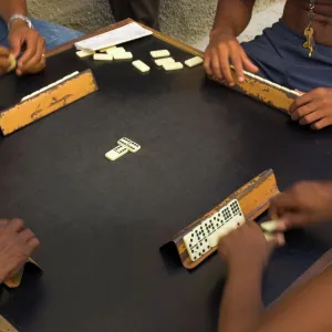 Close-up of the hands of a group of four people playing dominos in the street Centro Habana