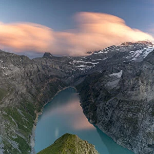 Clouds at sunset over the pristine lake Limmernsee and mountains, aerial view