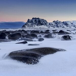 The cold wind that blows constantly shapes the snow on the rocks around Uttakleiv at dawn