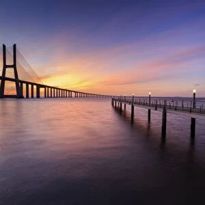 The colors of dawn on Vasco da Gama Bridge that spans the Tagus River, Lisbon, Portugal